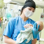 nurse holding a baby in neonatal nursing specialty hospital setting